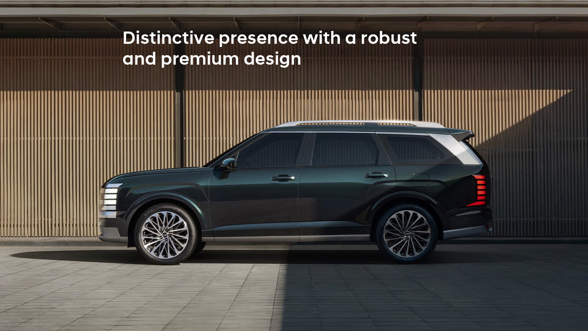 The all-new PALISADE side view, in front of a wall